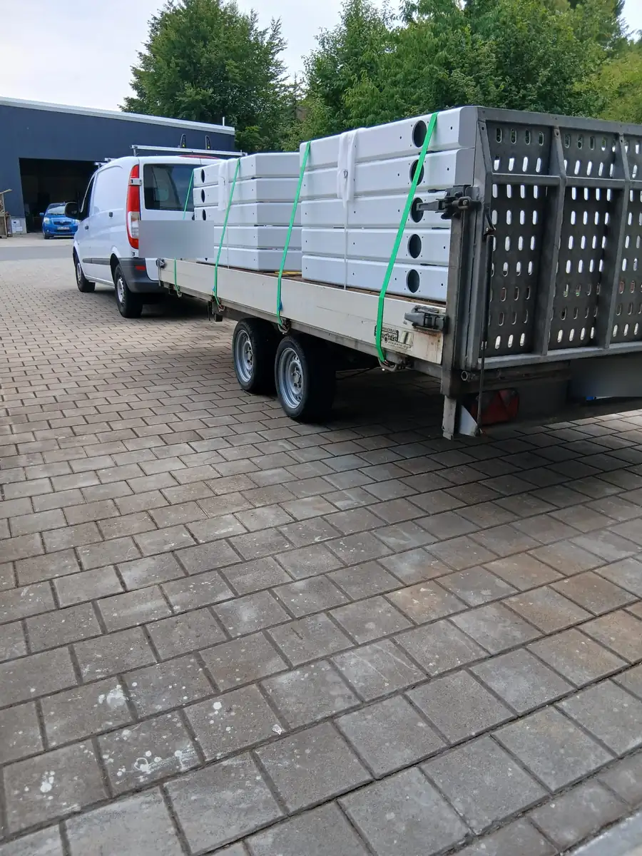 Transporter mit Anhänger, beladen mit fertig beschichteten und verzurrten Serienteilen